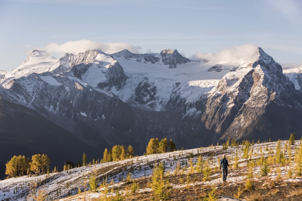 A hiker on a ridge above Monica Meadows trail in the Purcell Mountains near Meadow Creek, BC