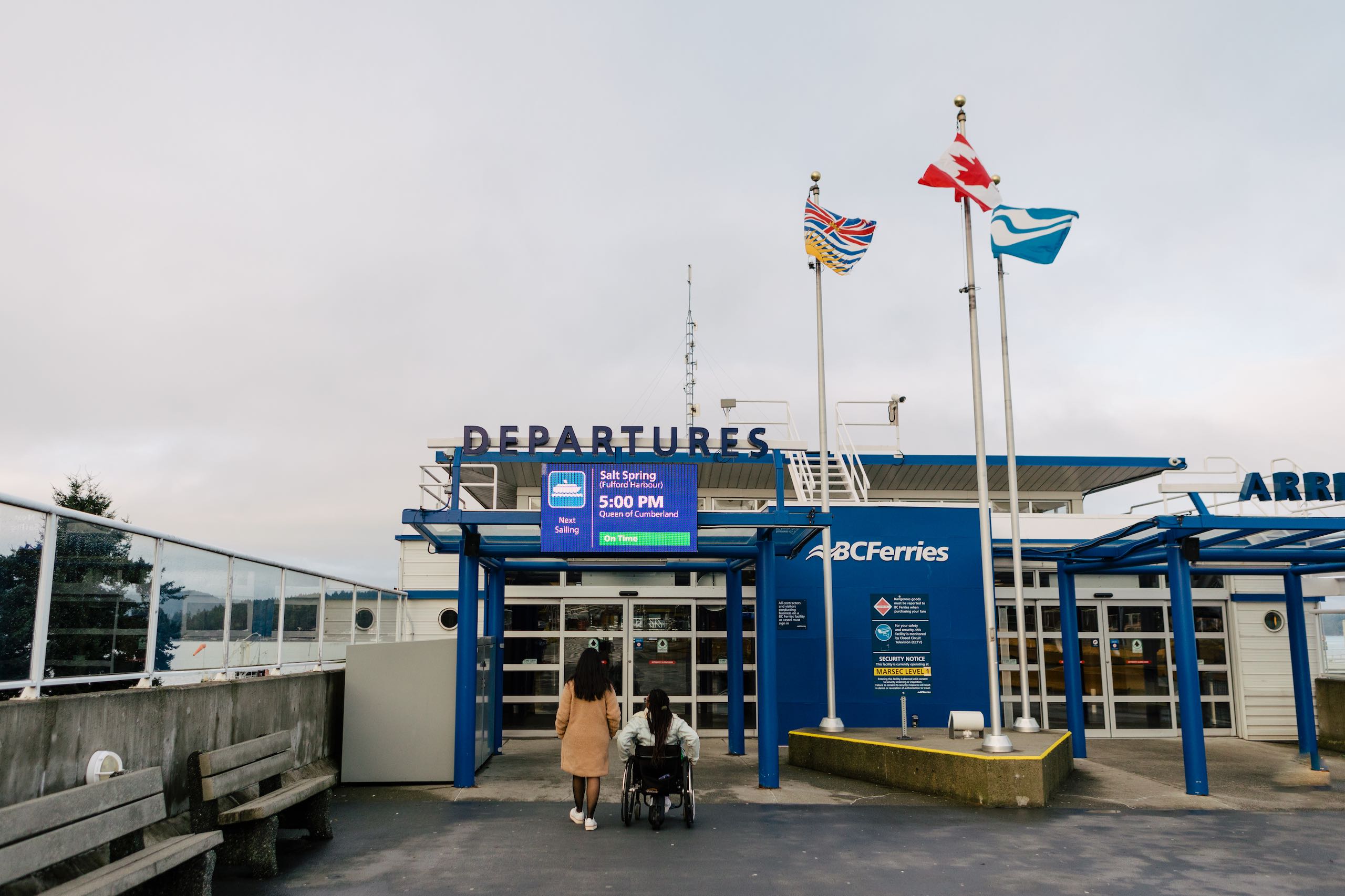Two people entering the Ferry Terminal at Swartz Bay, including one wheelchair user, on Vancouver Island