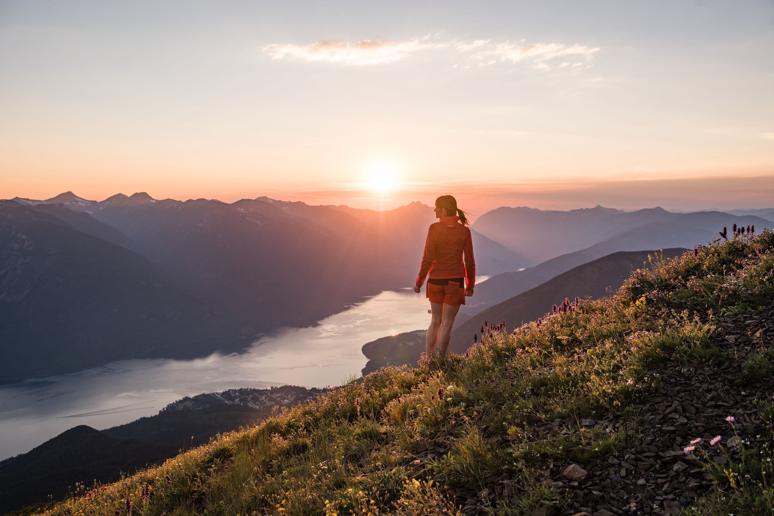A hiker at the summit of the Idaho Peak Lookout overlooking Slocan Lake near New Denver, BC