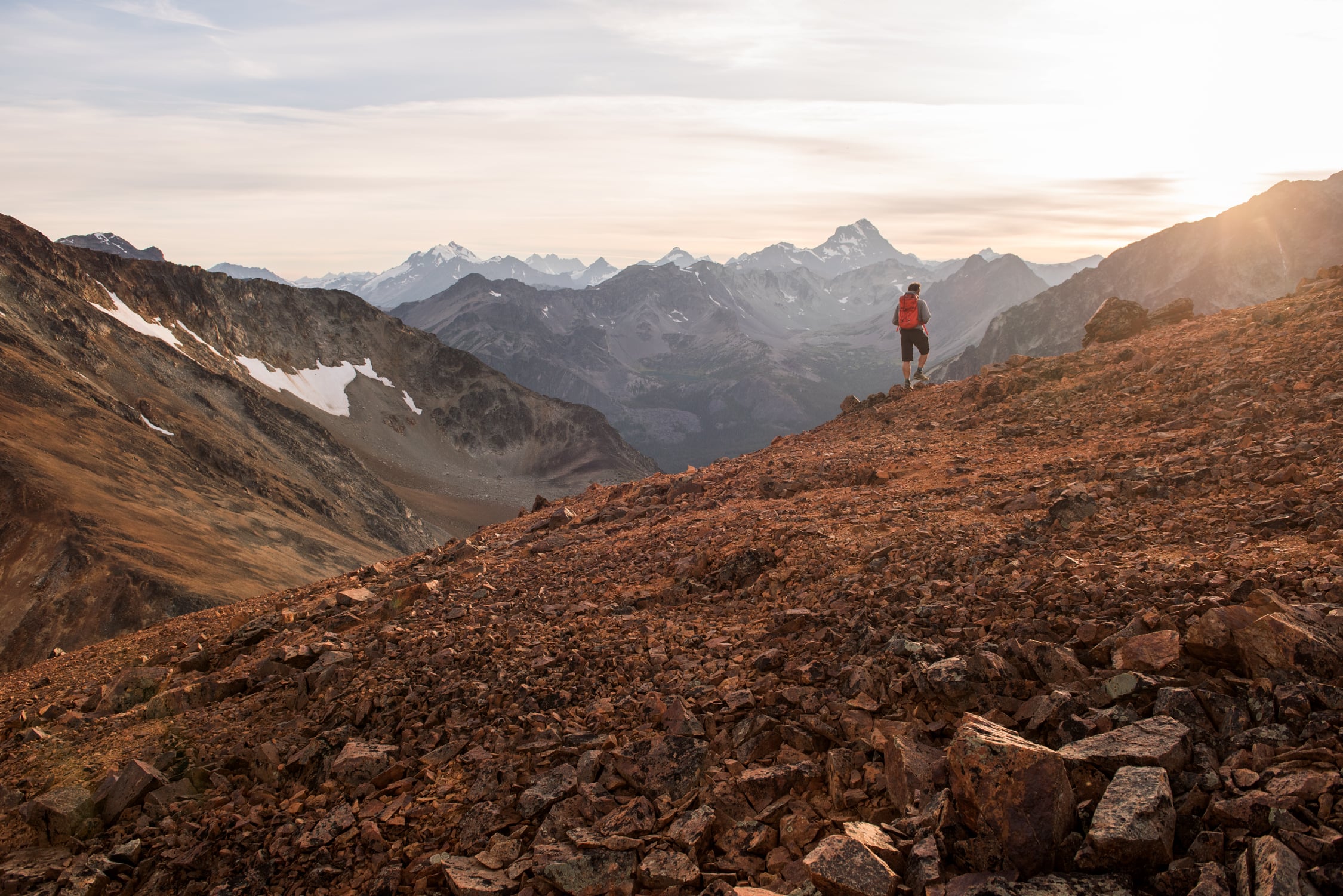 A hiker on a colourful ridge in the Niut Range, Coast Mountains, BC.