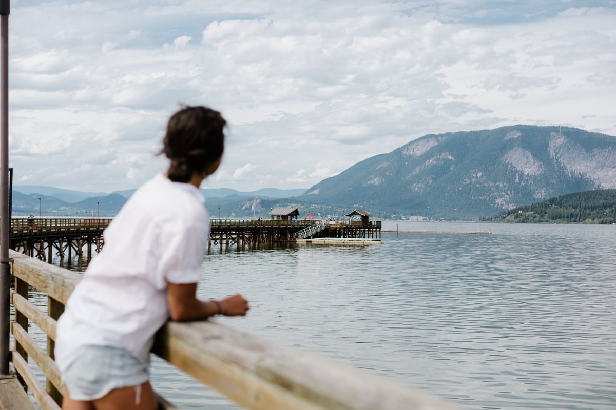 A woman looks out from the Salmon Arm Wharf to the water.